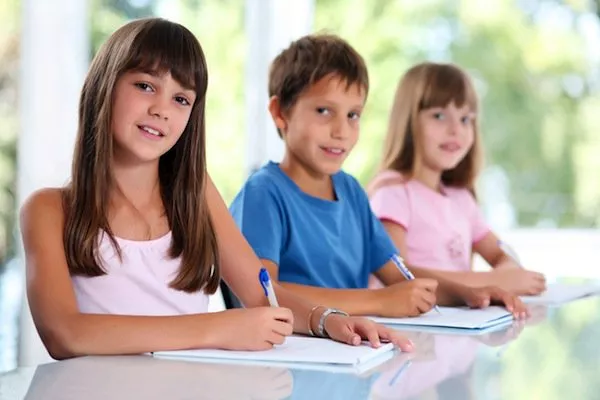 tre bambini che fanno i compiti a casa per scuola